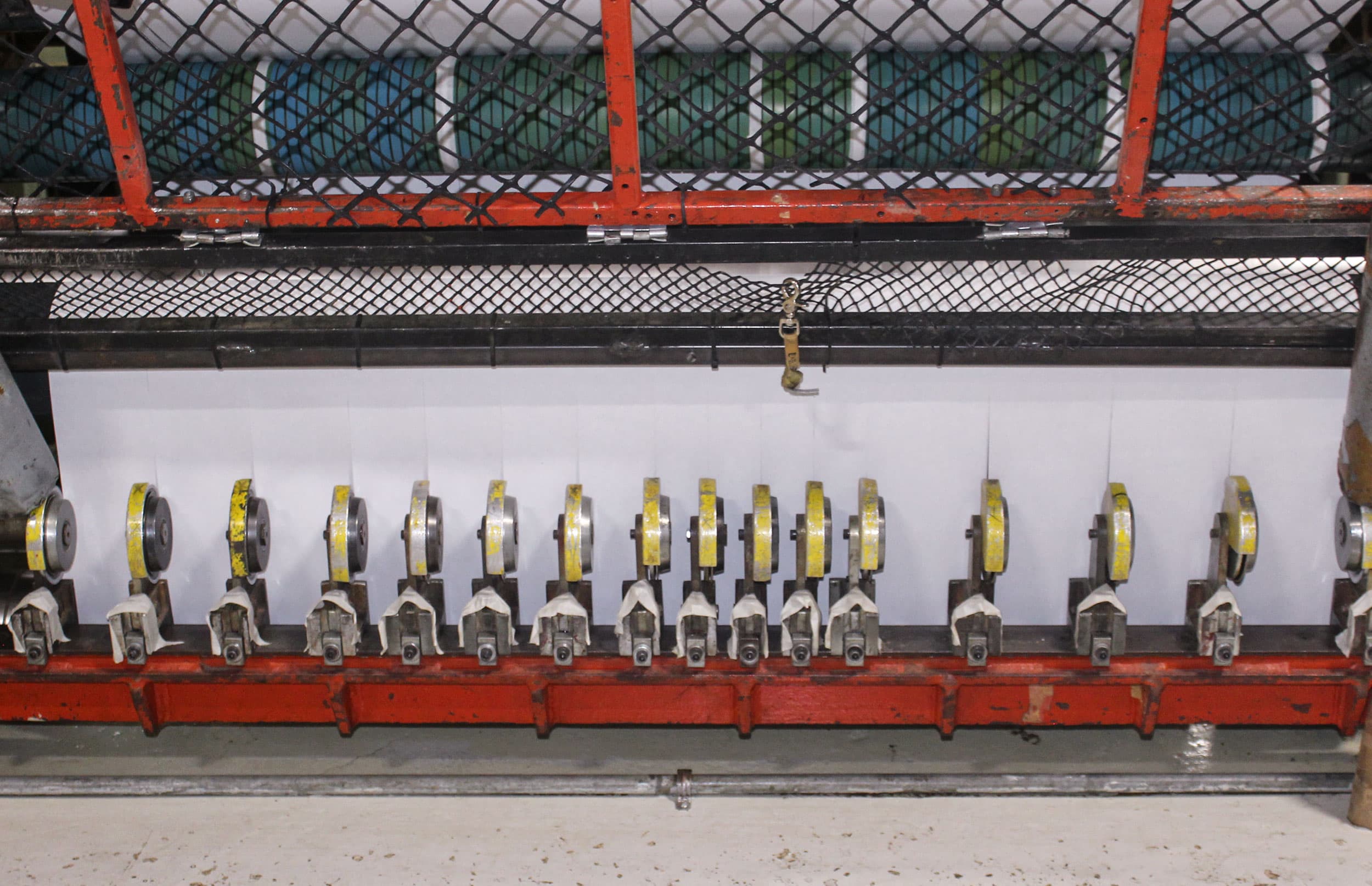 Bank of slitter knife holders positioned across a paper web at Paper Dimensions