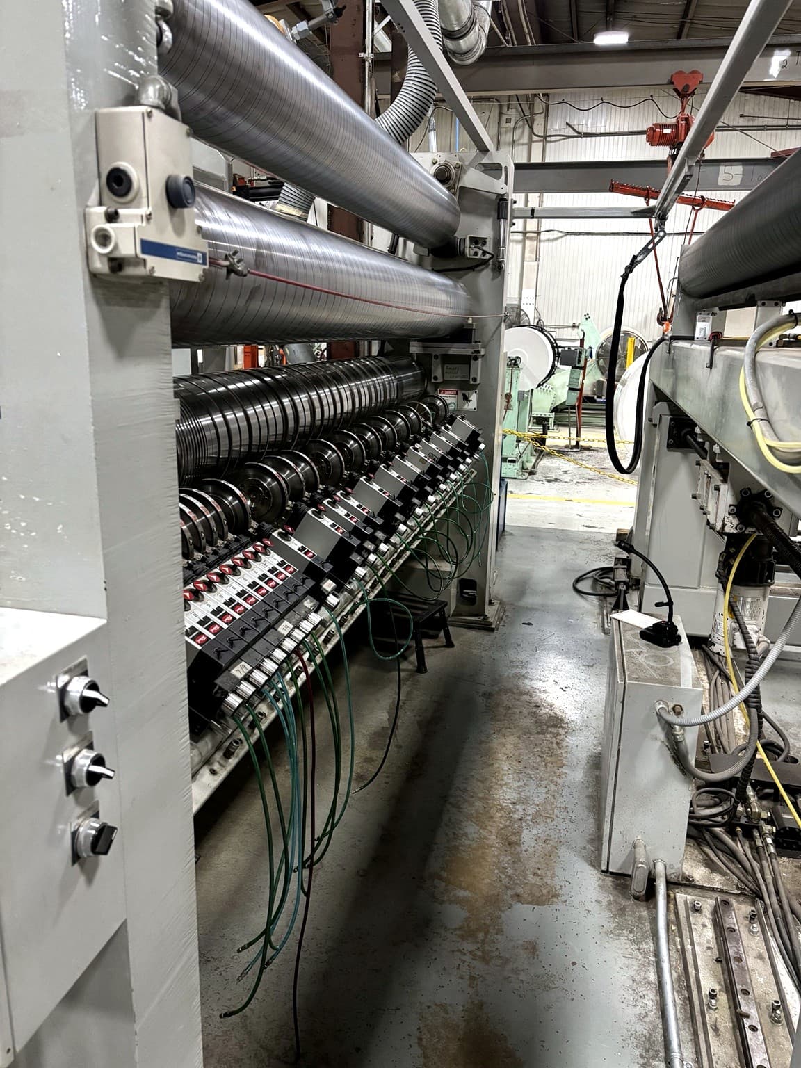 Close-up of the knife section on a Webco slitting machine at Paper Dimensions, used to convert Fire Resistant Paper to custom widths