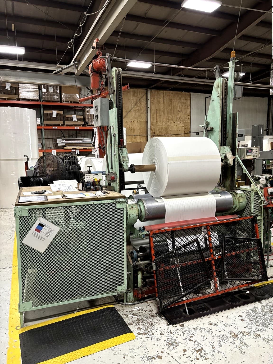 Close view of a paper slitting operation in progress at Paper Dimensions, showing precision roll converting on the production floor