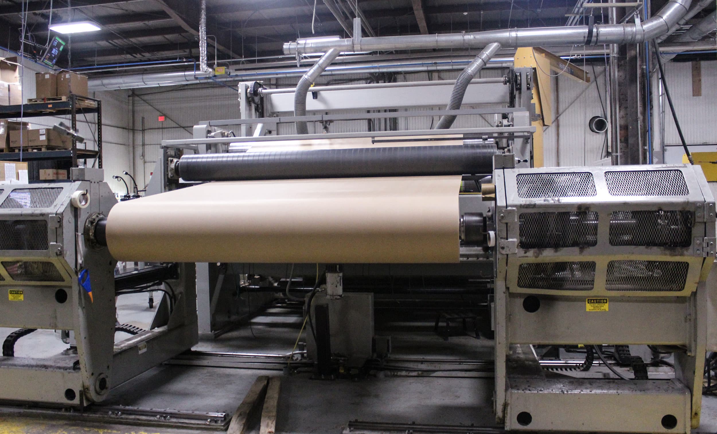 Paper web running through converting equipment on the production floor at Paper Dimensions