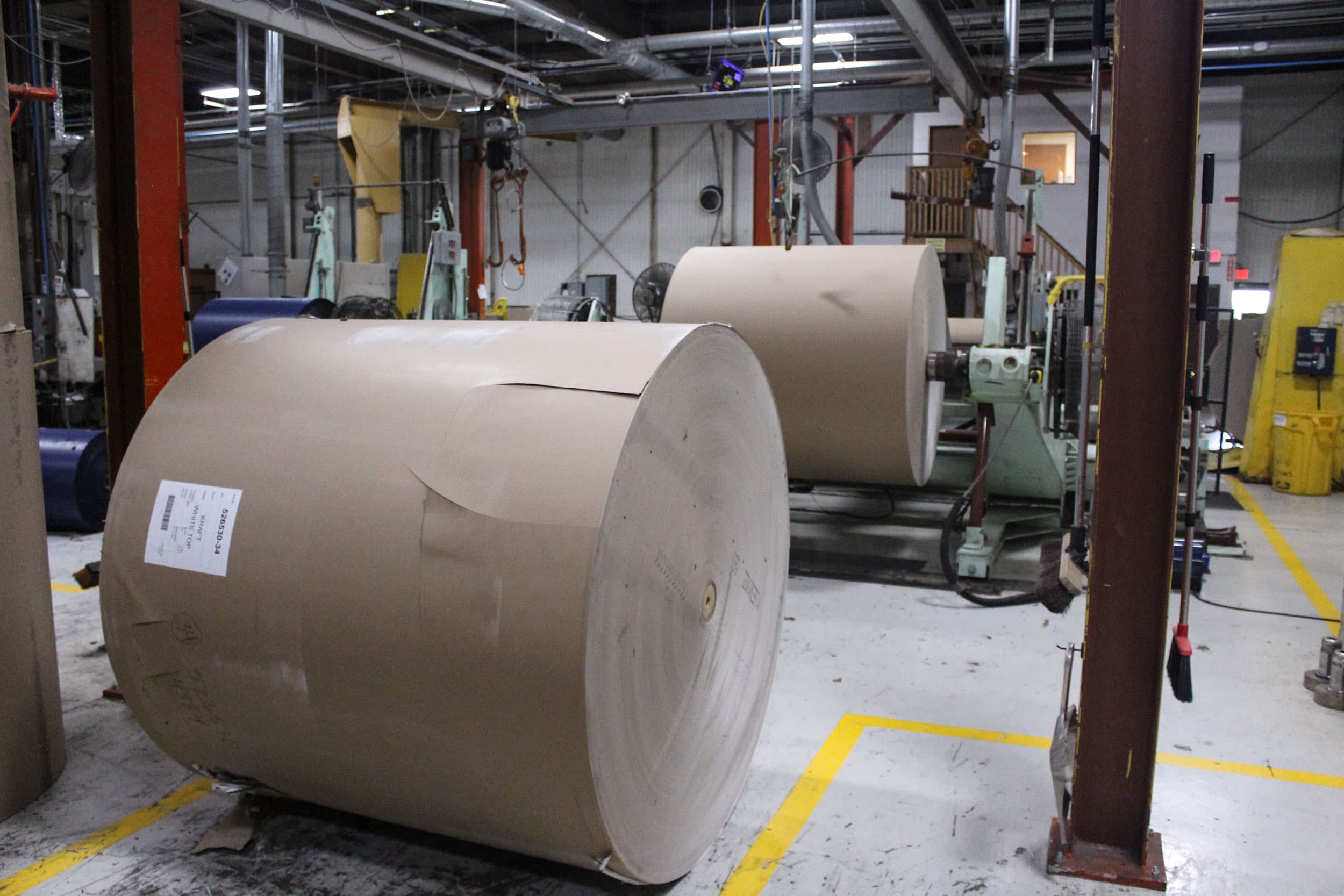 Two jumbo parent paper rolls staged on the production floor at Paper Dimensions