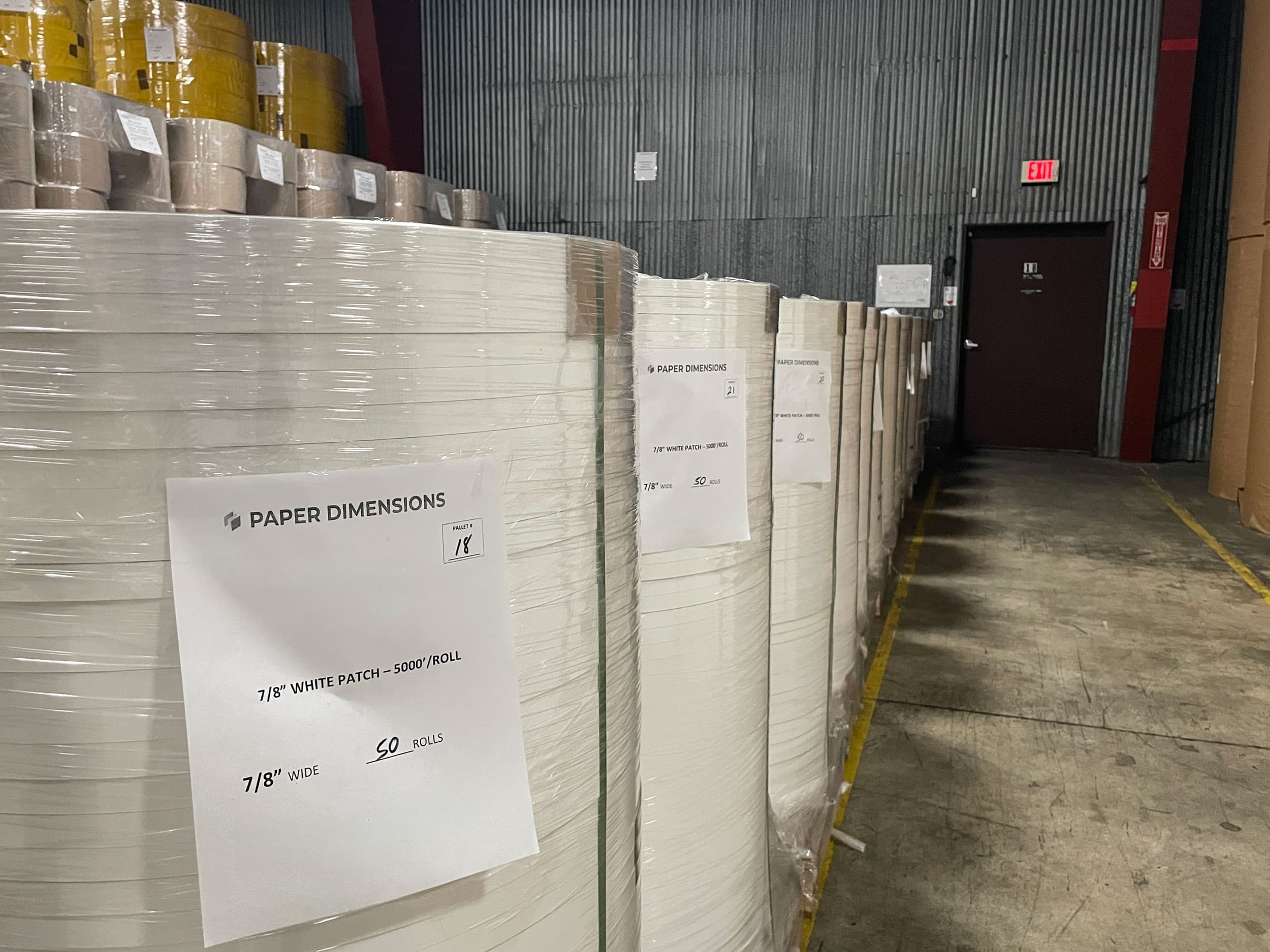 Pallet of Paper Dimensions Tag Stock labeled 7/8 inch White Patch, wrapped on a pallet